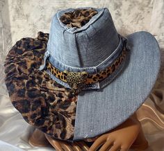 want to make a statement with their fashion choices.  This cheetah and denim cowgirl hat is a must-have for any fashion-forward woman who wants to add a unique touch to her wardrobe. The brand is handmade, making it a one-of-a-kind accessory. It is perfect for any casual or formal event and will complement any outfit. Diy Cowgirl Hat, Cow Print Stuff, Western Hats For Women, Denim Cowgirl, Denim Cowboy, Custom Made Hats, Cowgirl Style Outfits, Denim Crafts Diy, Leopard Print Fashion