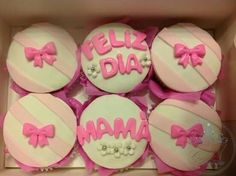 pink and white decorated cupcakes in a box with the words feliz diama on them