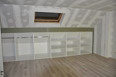 an empty room with white cabinets and wood flooring in the middle of it is being renovated