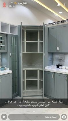 a kitchen with grey cabinets and white counter tops in arabic writing on the wall above it