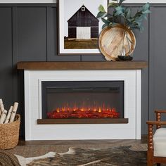 a living room with a fire place and pictures on the wall above it, along with a chair