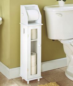 a white toilet sitting next to a sink and a cabinet in a bathroom with yellow walls