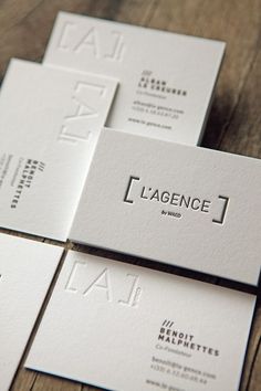 four business cards sitting on top of each other with the word'l'agence'printed on them