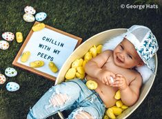 a baby laying in a bowl with rubber ducks on the ground next to eggs and a sign that says chillin with my pees