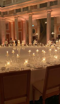 a long table is set up with candles and place settings for the guests to sit at