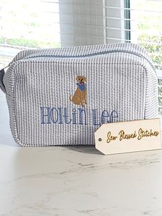 a blue and white striped bag sitting on top of a counter next to a sign