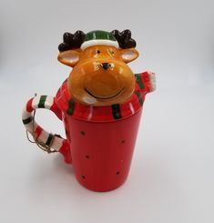 a ceramic cup with a reindeer head in it's mouth and scarf around its neck