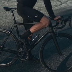 a man riding on the back of a bike down a street