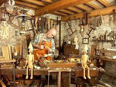 a man working in a woodworking shop with wooden mannequins