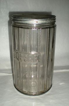 an empty glass jar sitting on top of a white table