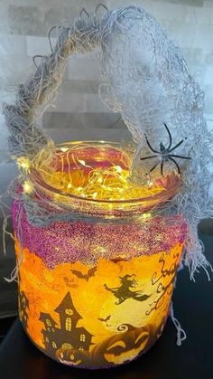 a glass jar filled with halloween decorations on top of a table