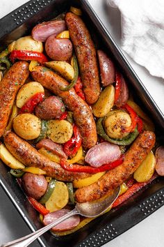 sausages, potatoes and peppers in a pan with a serving spoon on the side