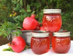 four jars filled with red liquid sitting on top of a table