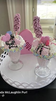 two vases filled with cake and candy on a table