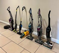 several vacuums lined up on the floor next to each other