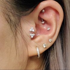 a close up of a person's ear with three piercings