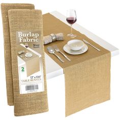 a table with place settings and napkins next to a burlap fabric banner