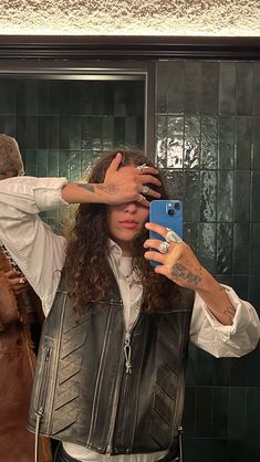 a man taking a selfie in front of a mirror with his hand on his head