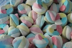 marshmallows with pastel colors are in a blue bowl on the table