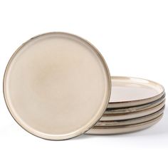 four white plates stacked on top of each other in front of a white background,