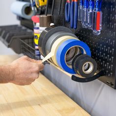 a man is using tape to attach the top of a machine