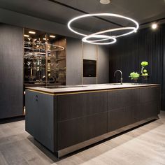 a modern kitchen with an island in the middle and lots of lights on the ceiling