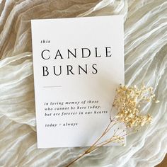 a card with the words, this candle burns is laying next to some dried flowers