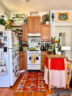 a cat laying on the floor in a kitchen next to a stove top oven and refrigerator