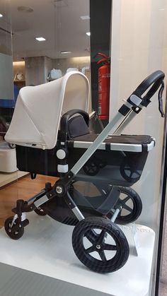 a black and white stroller on display in a store window