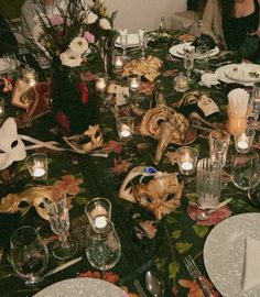 a table is set with masks and candles