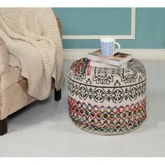 a coffee table with a book on top of it next to a chair and ottoman