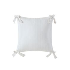 a white striped pillow with bows on the front and back side, sitting against a white background