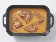 a casserole dish with meat in it on a white counter top, ready to be eaten