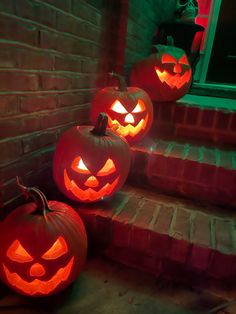 three carved pumpkins sitting on the steps