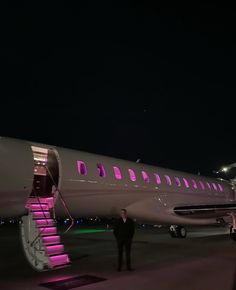 a large jetliner sitting on top of an airport tarmac next to a stairway