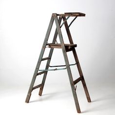 an old wooden ladder leaning against a white wall