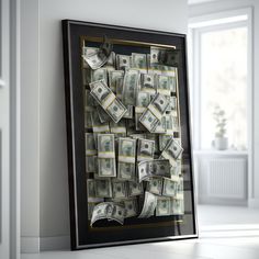 a black frame filled with money sitting on top of a white floor next to a window