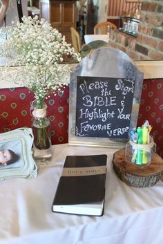 a table topped with pictures and flowers next to a chalkboard