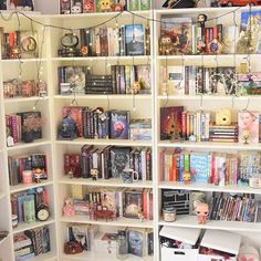 a book shelf filled with lots of books on top of white shelving unit units