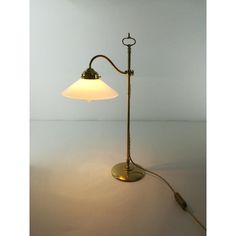 a lamp that is sitting on top of a white tablecloth with a cord attached to it