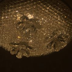 a chandelier hanging from the ceiling in a dark room with lights on it