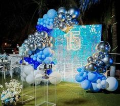 an outdoor event decorated with balloons and blue and silver decorations for a 50th birthday party