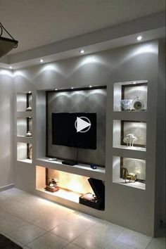 a modern living room with built in shelving and lighting