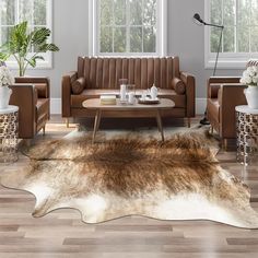 a living room filled with furniture and a cowhide rug