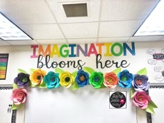 an office decorated with colorful paper flowers and congratulations blooms here written on the front wall