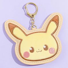 a keychain shaped like a pikachu with eyes and ears on it