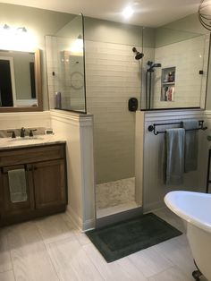 a white bath tub sitting next to a walk in shower