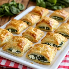 there are many small pastries on the plate and one is filled with spinach