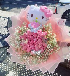 a hello kitty bouquet with pink roses and baby's breath