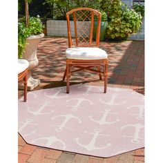 two chairs sitting on top of a pink rug in the middle of a patio area